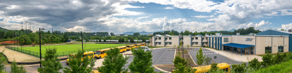 A panorama of the Franklin School of Innovation Campus depicting the building, the parking lot and the new athletic field